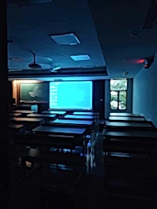 computer screen being projected in a large screen in a darkened room